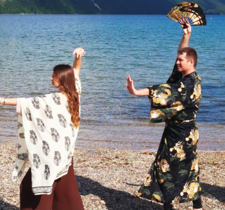 Deux personnes au bord d'un lac pratiquant une activité physique en tenues chinoises
