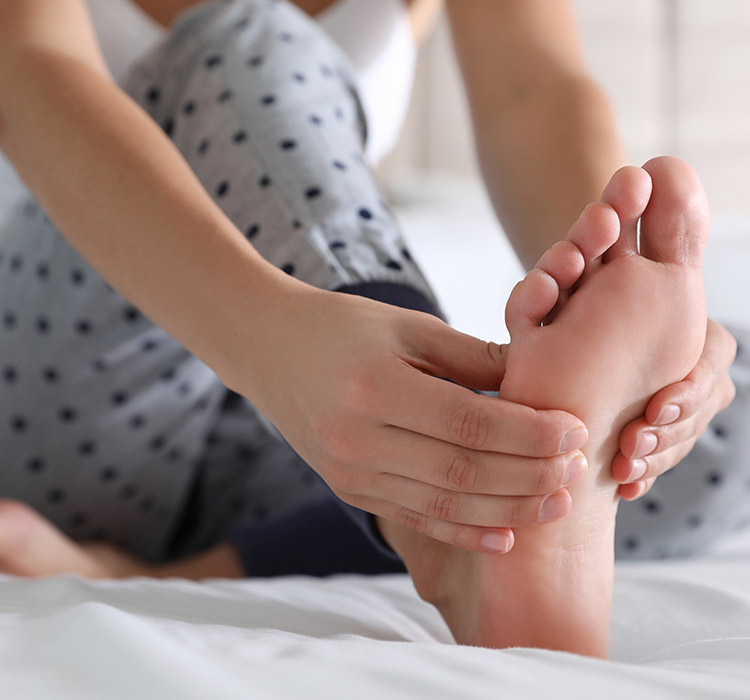 une femme se masse le pied
