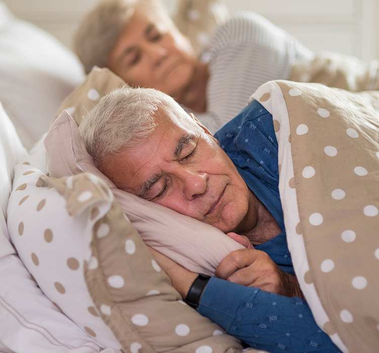 un homme dort dans un lit