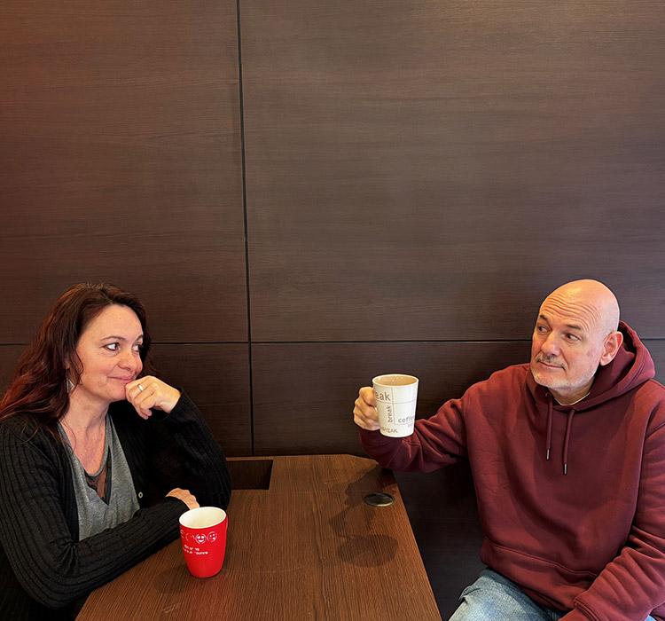 Une femme et un homme boivent un café autour d'une table