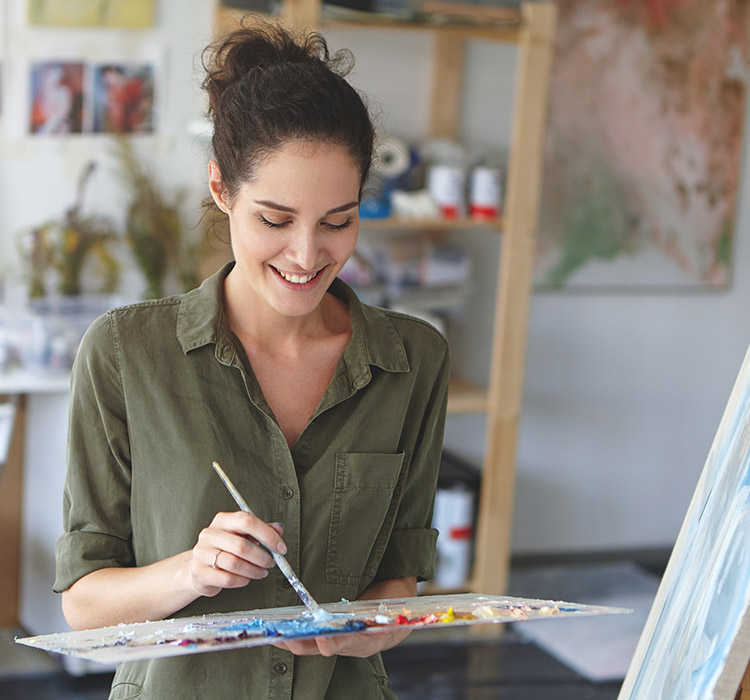une femme en train de peindre une toile