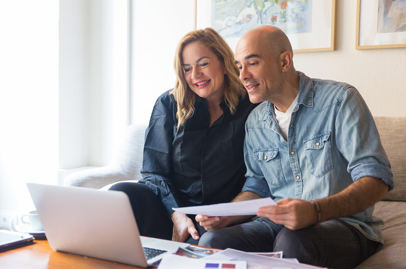 couple devant ordinateur avec des documents