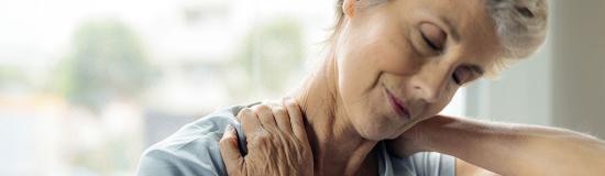 Une femme se tient le cou pour soulager sa douleur